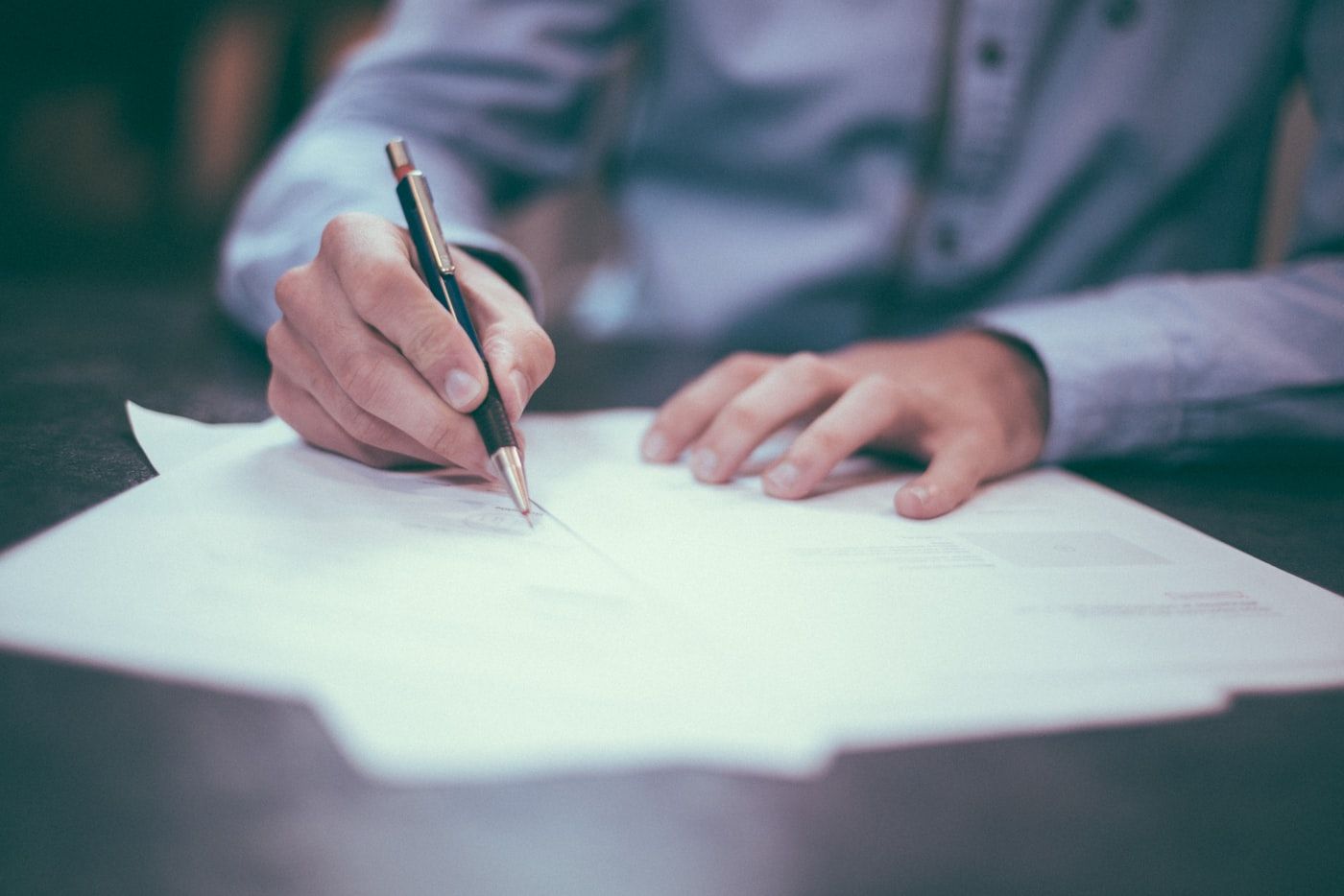 A person reviewing and signing property documents with a pen